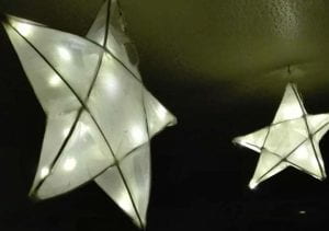 Two willow lanterns shaped like stars and glowing from within.