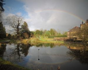 The main pool in the Garden in February with the long arc of a rainbow above, and reflected in the water.